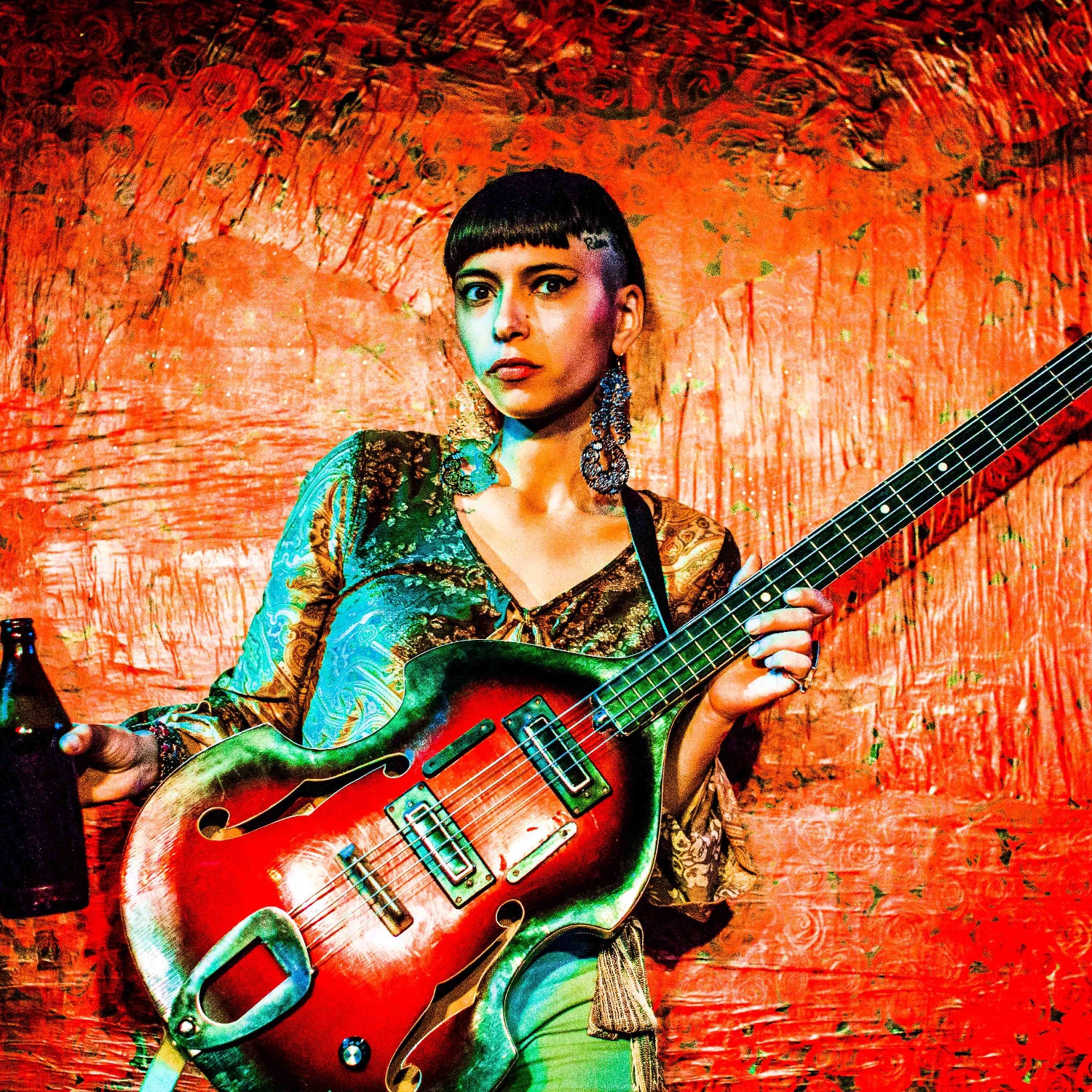 Person playing a red electric guitar against a textured red background